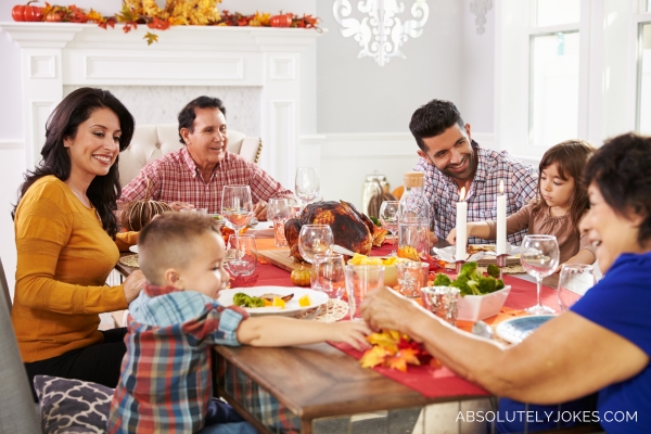 family enjoying Thanksgiving meal with turkey at the center of the table